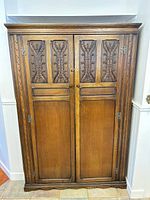 Front view of closed wardrobe showing carved doors and overall finish