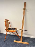 Full view of easel assembled showing mast, tripod legs, and paint box
