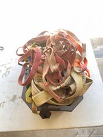 Pile of varied webbing straps in plastic bin
