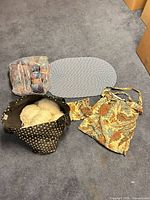 Lot overview showing yarn skeins, braided placemat, floral tote