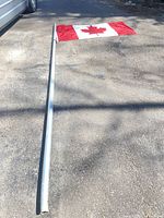 Flag attached to segmented aluminum pole lying on pavement