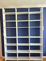 Front view showing full height white cubby bookcase with multiple compartments