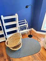 Group view of painted shelf, wall rack, baskets, braided rug