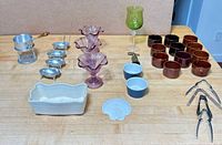 All items laid out on table showing glassware, ramekins, metal tools and ceramic dishes