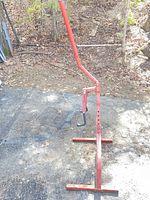 Full view of red steel adjustable motorcycle stand upright with base