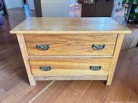 front view of solid wood chest showing two drawers and brass-tone bail pulls