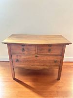 Front view showing three drawers, hardware, finish and legs