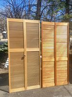 Front view of both louvered shutter panels standing side by side
