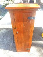 Front view of tall narrow pine cabinet