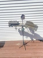 Full view of weather vane with train and car silhouettes on stand