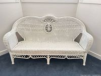 Front view of white wicker three-seat settee