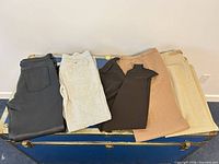 Five pairs folded on trunk showing colors and materials