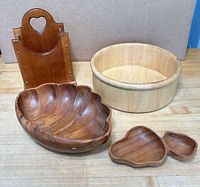 All four wooden items arranged on tabletop: scalloped bowl, round bowl, napkin/mail holder, divided tray