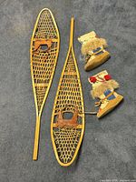 Full view pair wooden snowshoes and mukluks