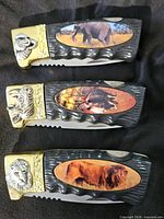 All three closed knives showing animal image inlays and bolsters