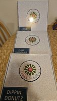Three sealed Cakes of Eden boxes: two Cake Turntable, one Dippin' Donutz
