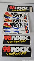 Seven vintage radio station bumper decals: three 98 Rock and four WQYK