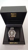 Watch inside open Mario Lopez display box showing full bracelet and branding