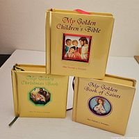 Front view of three gold hardcover children’s religious books standing