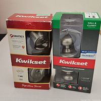 Both boxed Kwikset lock sets side by side