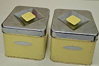 Front view of both yellow metal canisters showing labels