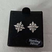 Front view of diamond cluster stud earrings on display card