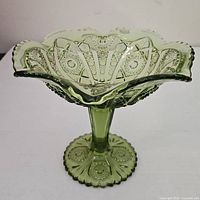 Top angled view of green pressed glass pedestal compote