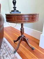 Full view of round mahogany end table beside sofa