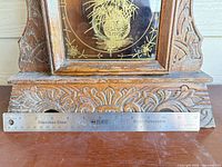 Clock base carving and ruler showing scale