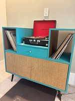 Full view of teal record cabinet housing Crosley turntable and vinyl records