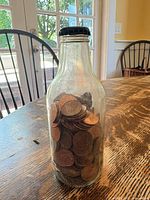 Full view of glass bottle filled with pennies