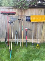 Group shot of all ten garden tools lined against fence