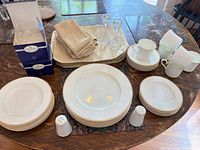 Full set arranged on table showing plates, cups, shakers, linens and crystal pieces
