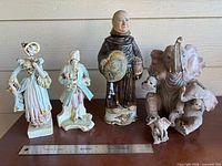 All four figurines with ruler for scale
