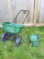 Walk-behind spreader and handheld spreader on grass