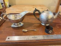 Group view of all five silver-plated items on tray with ruler for scale