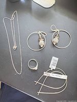 Full lot showing necklace, ring, two earring pairs and tags