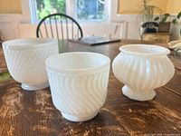 Group shot of three white milk glass planters
