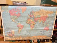 Full view of rolled-up world map mounted on shelf