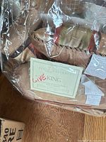 Original packaging showing label “7 Piece King Jacquard Bed Ensemble” and striped fabric inside