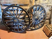 pair of antique wagon wheels leaning against wall