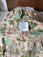 Folded scenic tapestry bedspread with lot sticker
