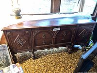 full front view of carved dark walnut sideboard showing overall design and condition