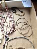 Overview showing pink seed bead necklace, gold bangles, rhinestone headband, elastic beaded bracelet