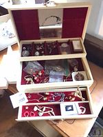 Open jewellery box showing multiple tiers and jewellery pieces