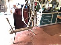 Side view showing full spinning wheel structure, bench, chair back, large wheel, paint finish, missing flyer