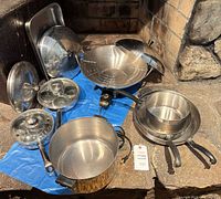 Group shot of entire cookware set including pots, pans, lids, egg poacher insert and electric wok