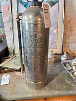 Full view of nickel-plated brass extinguisher with hose