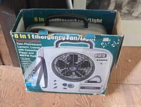 Box of 8-in-1 rechargeable emergency fan light radio combo