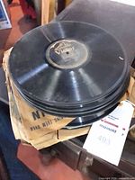Stack of 10" shellac records on surface with paper sleeves